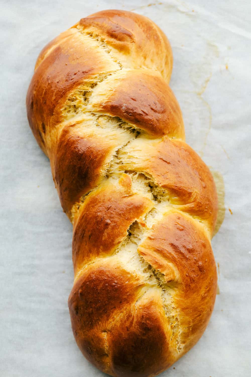 Challah Bread is a rich and fluffy loaf full of flavor. A Jewish traditional loaf, this incredible bread is going to be a favorite in your family baking! Golden brown baked challah bread.