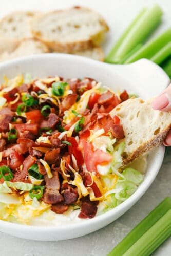 Creamy BLT Dip is an appetizer that is delightfully light and oh so good! A creamy seasoned base is topped with all the flavors of the classic BLT, you are going to love it! Creamy bacon lettuce and tomato dip with bread.