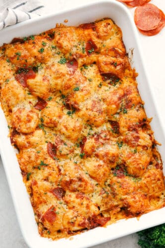 Bubble pizza is a fabulous spin on pepperoni pizza that is easy and crazy good! Soft pillowy biscuits are smothered in sauce, pepperoni, and topped with cheese! Bubble pizza in a 9x13 ready to eat.