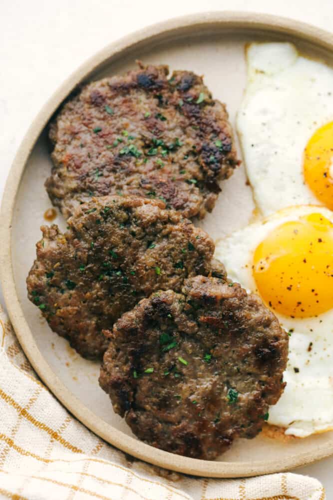 Homemade Breakfast Sausage is easier to make than you think and tastes way better than you can imagine! This is going to change the way you do breakfast. A plate of sausage with eggs on the side.