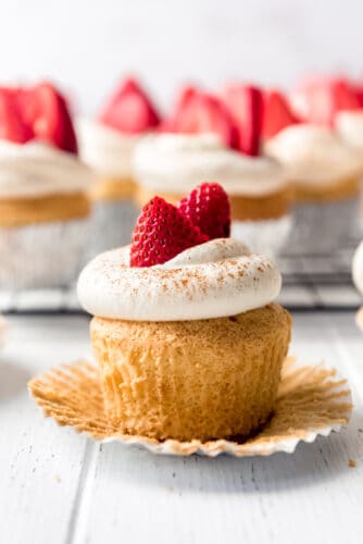 Light, fluffy Tres Leches Cupcakes are drenched in a three milk mixture, just like classic Tres Leches Cake, but in the handheld form! Topped with sweetened whipped cream, a light dusting of cinnamon, and fresh strawberries, these make a wonderful finish to any Mexican dinner! an unwrapped tres leches cupcake