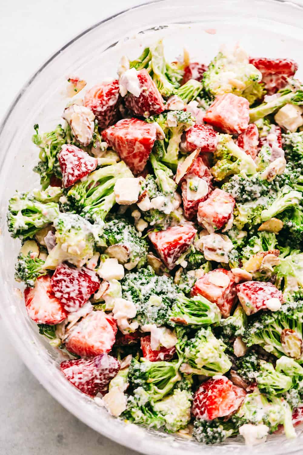 Creamy Broccoli Salad is a delicious broccoli salad with fresh strawberries, almonds, and feta cheese. The strawberries give the salad such a great and sweet taste and the creamy dressing on top is the best! Bowl of Creamy Strawberry Broccoli Salad.