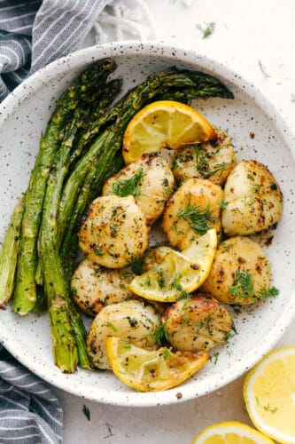 Air Fryer Lemon Dill Scallops are going to change the way you eat scallops! These are chock full of flavor, tender, juicy and succulent! Scallops with asparagus and lemons in a bowl.