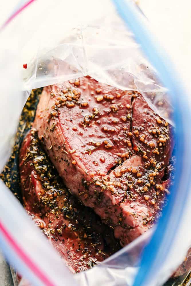 World's Best Steak Marinade adds so much flavor to your juicy steak. It helps to tenderize and infuse the steak with flavor and creates the best steak ever! Uncooked steak in a Ziplock bag with the steak marinade.