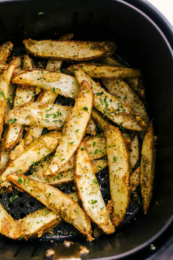 Air Fryer Potato Wedges are crispy and seasoned on the outside and perfectly tender on the inside! These are so insanely delicious you are going to love them! Cooked potato wedges in the air fryer ready to eat.