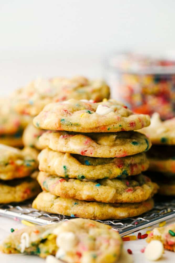 Funfetti Cheesecake Pudding cookies are some of the best tasting and best looking cookies you'll ever have! Made with pudding mix, these are soft, chewy and oh so delicious! Stacks of Cookies on a cooling rack.