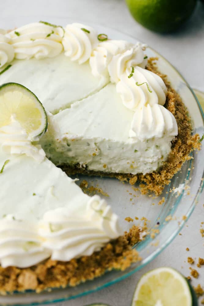 No Bake Key Lime PIe is a slice of tropical heaven. This has a sweet crunchy crust filled with a refreshing, creamy and zippy lime filling perfect for the summer heat! The no-bake key lime pie with a piece missing.