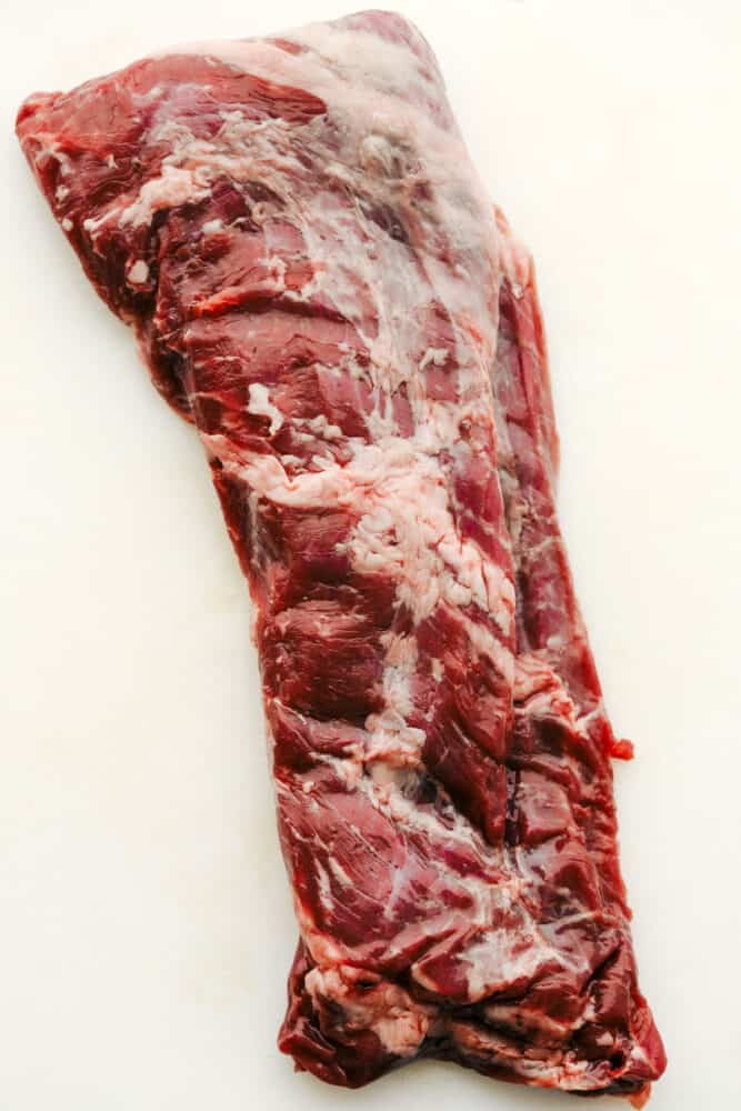 Grilled Skirt Steak is juicy, full of bold flavor, and absolutely delicious. Grilling skirt steak brings out the best of this long thin steak that you are going to love. A raw skirt steak.