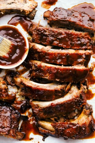 Slow Cooker ribs are going to melt in your mouth and fall off the bone! They are cooked low and slow so they are perfectly tender and then covered in a sauce that's absolutely to die for! Slow cooker ribs separated with sauce.