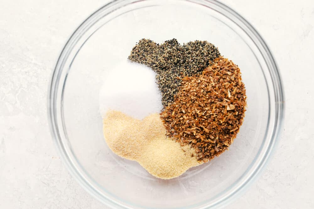 Lemon Pepper Seasoning is a little bit zingy and a little bit peppery, and a whole lot delightful! Making your own lemon pepper is super easy and absolutely delicious. Ingredients in lemon pepper in a bowl.