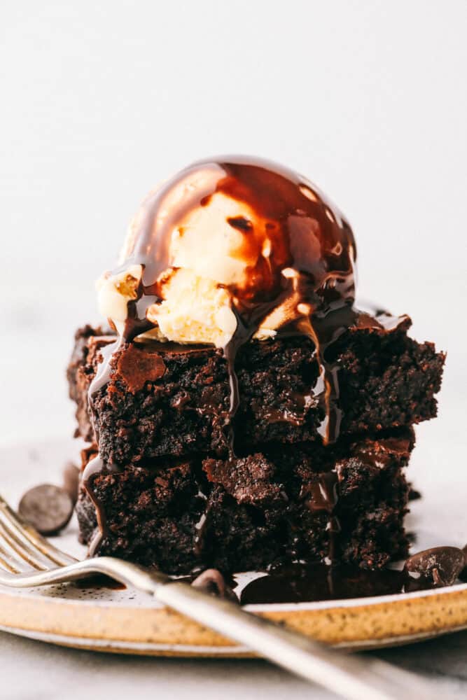 These are truly the Most Perfect Brownies Ever! These are rich, decadent and full of soul satisfying chocolate! Two brownies with ice cream and chocolate sauce dripping down the sides.