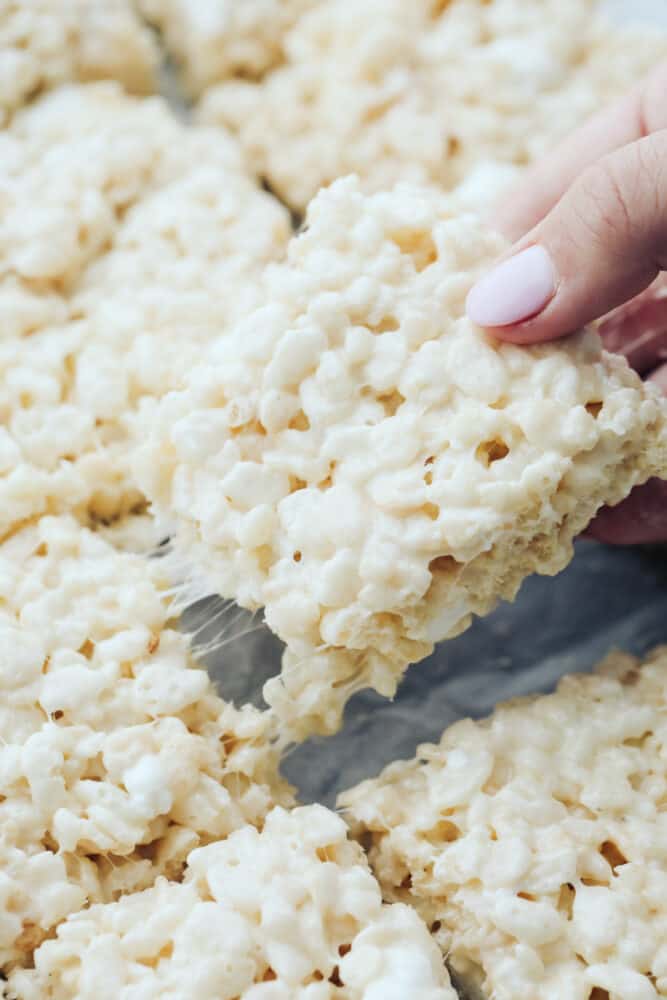 Everyone loves a good rice krispie treat. Sweet, soft, and extra ooey gooey, these Perfect Rice Krispie Treats will become your new favorite! Rice krispie being pulled from pan