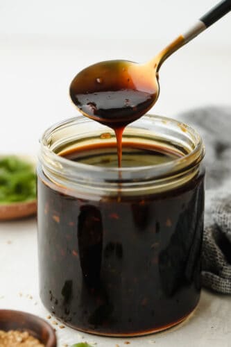 Homemade Teriyaki Sauce is super easy and way better than store-bought! Made with simple ingredients you can pronounce, this is going to become a staple in your family. Spooning teriyaki sauce out of jar.