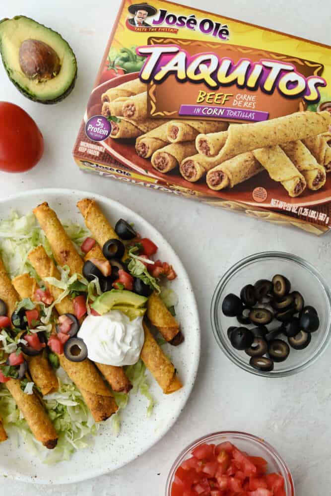 These air fryer frozen taquitos are quick and easy to make for a snack, dinner or side dish! Inside each taquito is packed with protein and flavor! Jose Ole taquitos on a white plate with the Jose Ole taquitos box next to it.