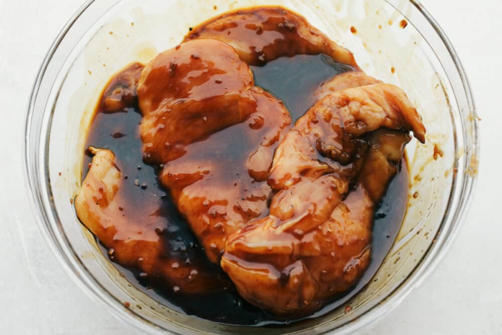 Grilled Teriyaki Chicken is the ultimate quick and easy, absolutely delicious dinner! Tender juicy chicken is soaked in the BEST Teriyaki Sauce then grilled to perfection Raw chicken marinating in the teriyaki sauce.