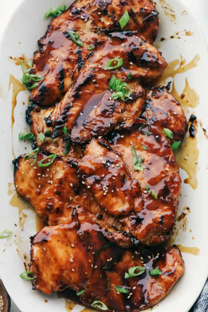 Grilled Teriyaki Chicken is the ultimate quick and easy, absolutely delicious dinner! Tender juicy chicken is soaked in the BEST Teriyaki Sauce then grilled to perfection Grilled chicken with teriyaki sauce on a white plate.