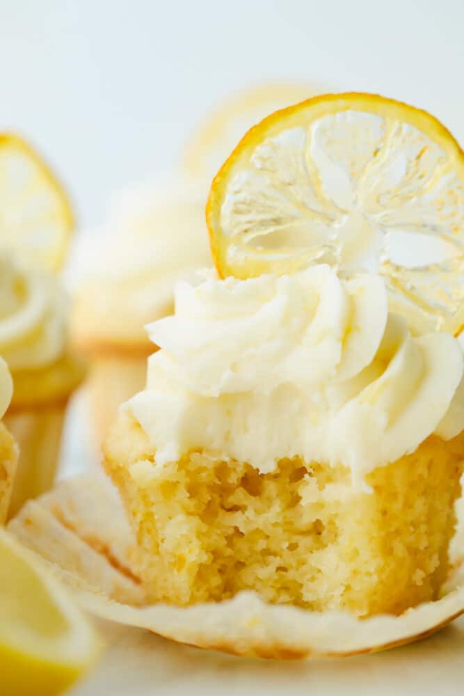 The AMAZING sweet and zesty flavors of these Lemon Cupcakes will have you hooked! Fresh lemon adds a pinch of summer to a classic, decadent treat. Lemon cupcake with a bite taken out of it