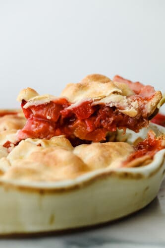 A sweet, tart fruit filling and golden, flaky crust make this Strawberry Rhubarb Pie the dessert of the summer. With a pie this fresh and decadent, you won't want store-bought again! Slice being taken out of strawberry rhubarb pie.