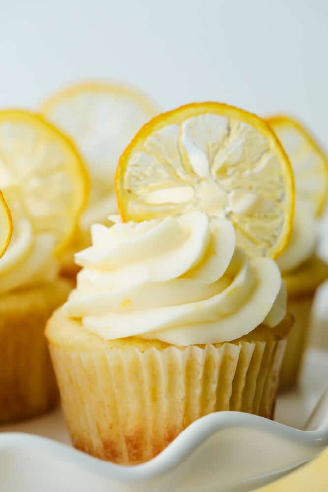 Candied Lemon Slices are super easy and a delicious way to decorate your favorite lemon foods. These lemon slices are so good you may just eat them before they get a chance to be a decoration! A lemon cupcake decorated with a dried candied lemon slice.