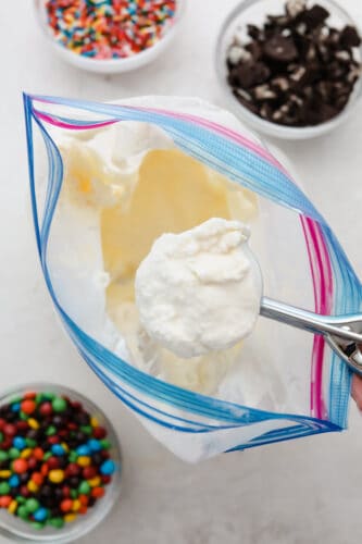 Ice cream in a bag is the perfect summer time kid-friendly treat! Super simple and absolutely delicious, this science project is one your kids are going to want to keep on repeat. Homemade ice cream in a bag being scooped out with a spoon.