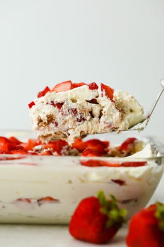 Strawberry Icebox Cake is the cool, creamy, and moist no-bake dessert of your dreams. Add a pop of juicy strawberry and you will never want to make cake another way! Serving a piece of Strawberry Icebox Cake.