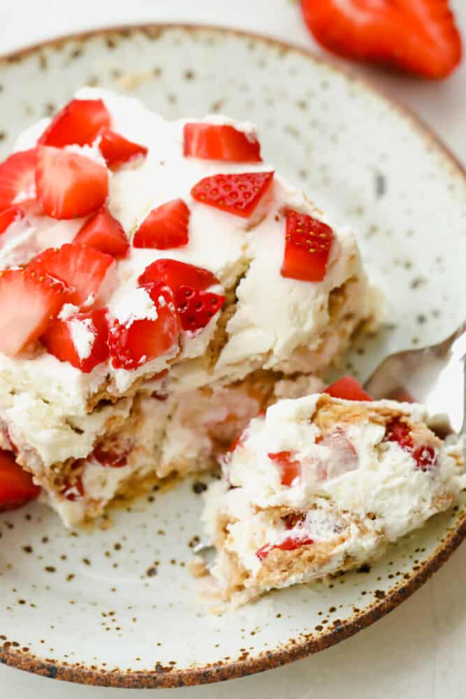 Strawberry Icebox Cake is the cool, creamy, and moist no-bake dessert of your dreams. Add a pop of juicy strawberry and you will never want to make cake another way! Having a spoon of icebox cake.