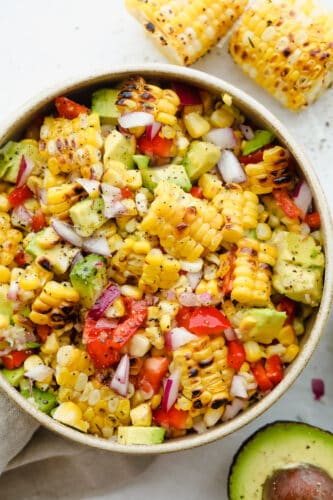 Don't let the name fool you, this Summer Corn Salad definitely can (and should be!) enjoyed all year round! It's a fresh corn salad made with onion, bell pepper, avocado, and.....corn! Fresh or frozen corn will work A bowl full of summer corn salad ready to eat.