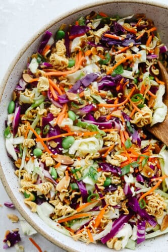 Asian Ramen Salad is full of color, flavor, and crunch! All of the fun textures make it perfectly satisfying and insanely delicious! A bowl of colorful Asian Ramen salad.