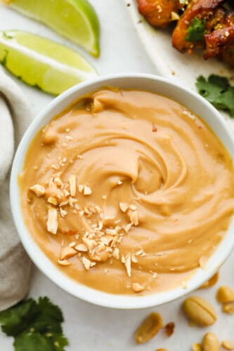 Add a hint of delicious Thai cuisine with this super easy sauce that is the perfect blend of savory and sweet. Peanut Sauce is so addictive- you will want to put it on everything! Bowl of peanut sauce with peanut garnish.
