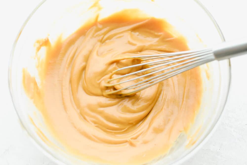 Add a hint of delicious Thai cuisine with this super easy sauce that is the perfect blend of savory and sweet. Peanut Sauce is so addictive- you will want to put it on everything! Whisking Peanut Sauce ingredients together.