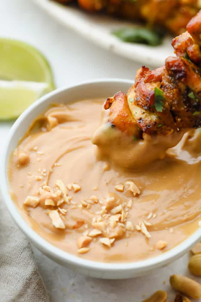 Add a hint of delicious Thai cuisine with this super easy sauce that is the perfect blend of savory and sweet. Peanut Sauce is so addictive- you will want to put it on everything! Dipping a skewer in Peanut Sauce.