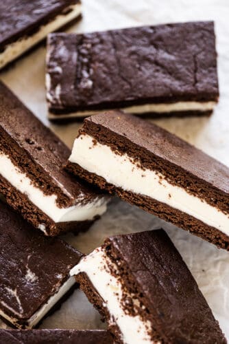 This homemade ice cream sandwich recipe is the ultimate summer treat. They're made with your favorite ice cream that's sandwiched between a brownie-like crust that stays soft even when frozen. Make a big batch and enjoy them all summer long! homemade ice cream sandwich bars on a serving plate.