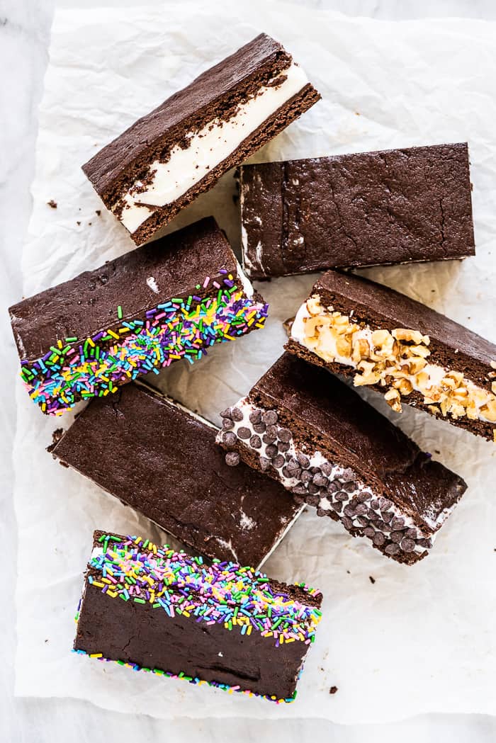 This homemade ice cream sandwich recipe is the ultimate summer treat. They're made with your favorite ice cream that's sandwiched between a brownie-like crust that stays soft even when frozen. Make a big batch and enjoy them all summer long! Homemade ice cream sandwiches with sprinkles and chocolate chips.