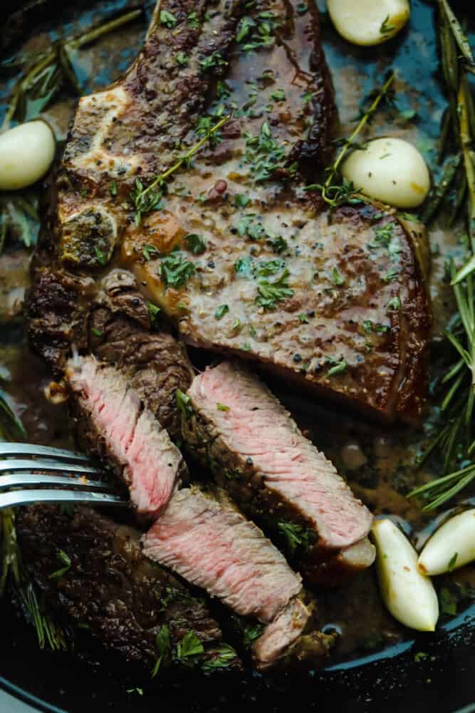 Achieving steakhouse-worthy flavors doesn’t have to be difficult! The ultimate ribeye steak is juicy, flavorful, and seared to perfection all in the comfort of your kitchen. Cutting off slices of steak.