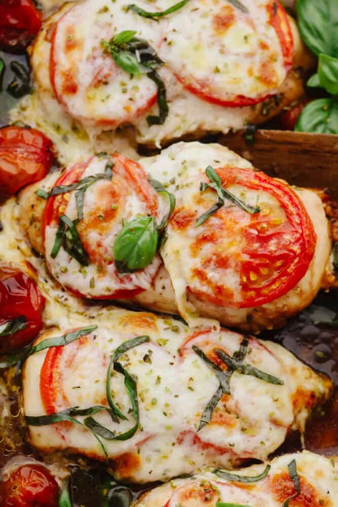 Baked Caprese chicken is nothing less than delicious and delightful! It's fancy enough for company but simple enough for a quick and easy weeknight dinner that your family will go crazy for! Close up of baked chicken.
