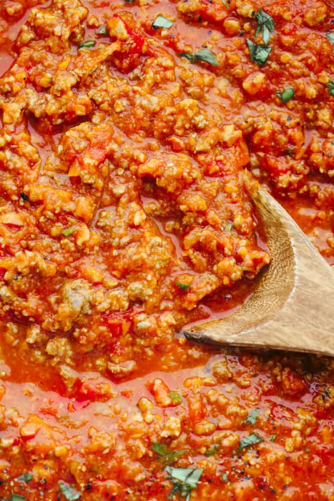 Bolognese sauce is heavenly and boy is the texture is something to write home about! With some love and patience, this sauce will turn out to be a work of art and TOTALLY worth the time you put into it!! Zoomed in picture of the sauce with a wooden spoon in it.