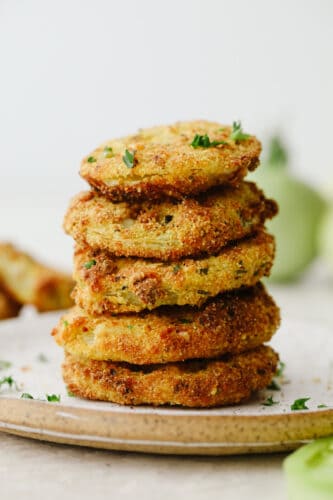 Air fryer fried green tomatoes are insanely delicious! Crispy on the outside and tender and juicy on the inside, these tomatoes will knock your socks off! Stack of fried green tomatoes.
