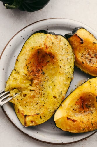 Roasted parmesan acorn squash is deliciously smooth and loaded with flavor! Mixed with these amazing spices, once this is cooked up, you will have found your own little slice of heaven! Roasted acorn squash with a fork.