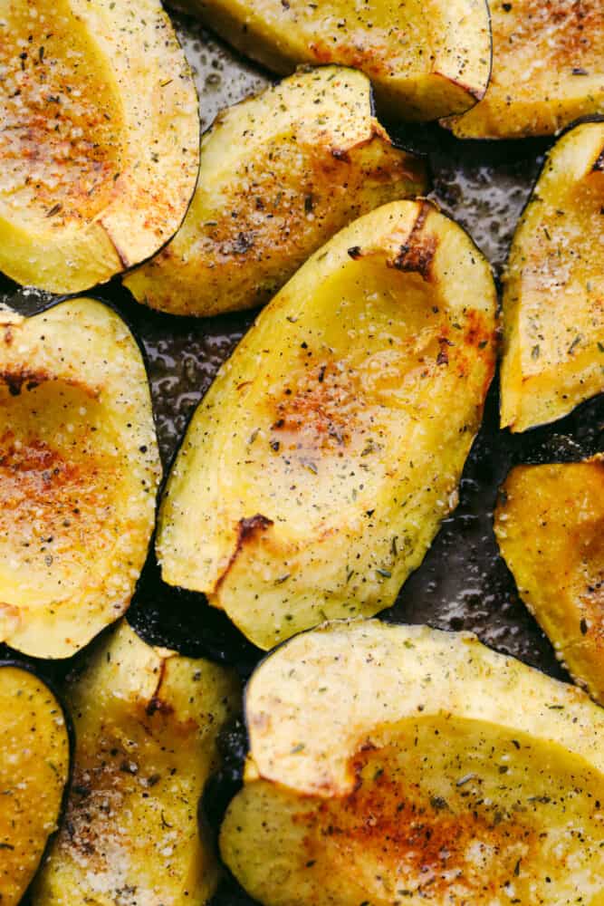 Roasted parmesan acorn squash is deliciously smooth and loaded with flavor! Mixed with these amazing spices, once this is cooked up, you will have found your own little slice of heaven! Roasted parmesan acorn squash on a pan.