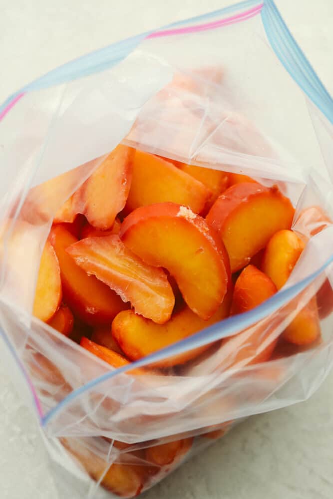 Freezing peaches is the best because they can be used in EVERYTHING! If you want to enjoy delicious peaches all year round then look no further because, with this recipe, you can have juicy, delicious peaches whenever you want! Frozen, sliced peaches in a ziplock bag.