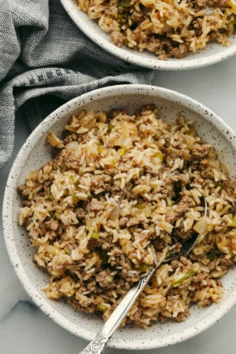 Dirty rice is packed with Cajun flavor and the texture is to die for! It has the most amazing blend of delicious spices, meats, and rice that will definitely be something that your family will go crazy for! Dirty rice in a bowl with a spoon.