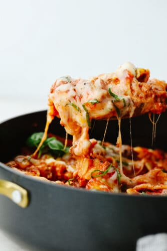 Skillet lasagna is the absolute best comfort food! It is so full of flavor that creates that authentic Italian taste. It is quick and easy and a family favorite that you MUST try! Skillet lasagna being served up with a large spoon.