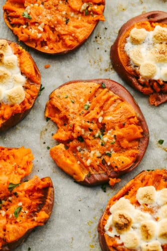 Smashed sweet potatoes are crispy on the outside and soft and smooth on the inside! They can be cooked to taste sweet OR savory and they both have a mouthwatering taste that is divine! You will love every single bite! Sweet potatoes on a tray.
