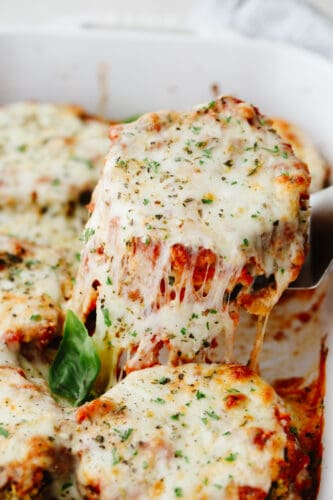Eggplant parmesan is a tangy, crispy, cheesy masterpiece! Delicious eggplant covered in a delightful mix of herbs and spices, this recipe will knock your socks off! Eggplant parmesan being dished up.