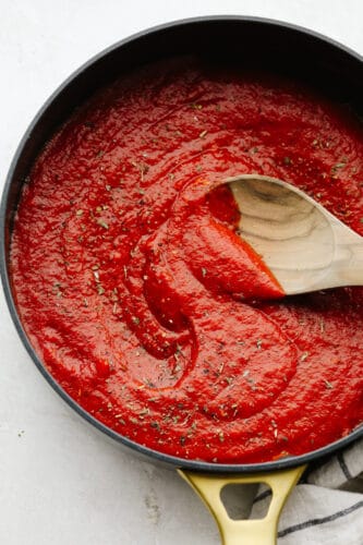 Using homemade pizza sauce is the perfect way to level up your pizzas! It's loaded with sautéed garlic, fresh herbs, and only takes 5 minutes to make! Finished pizza sauce in a saucepan.