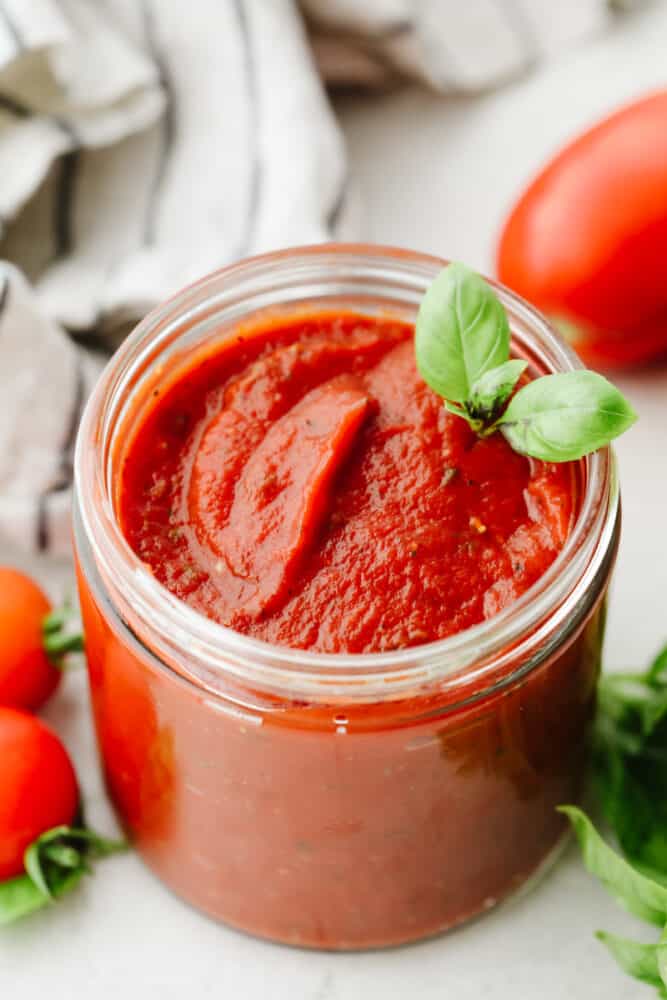 Using homemade pizza sauce is the perfect way to level up your pizzas! It's loaded with sautéed garlic, fresh herbs, and only takes 5 minutes to make! A jar of homemade pizza sauce with
