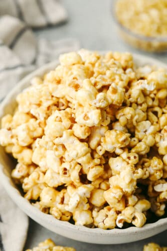 Homemade caramel popcorn is soft, sweet, and absolutely delicious! A family favorite, this homemade popcorn is something you will definitely want to add to your weekly movie nights! Caramel popcorn in a bowl.