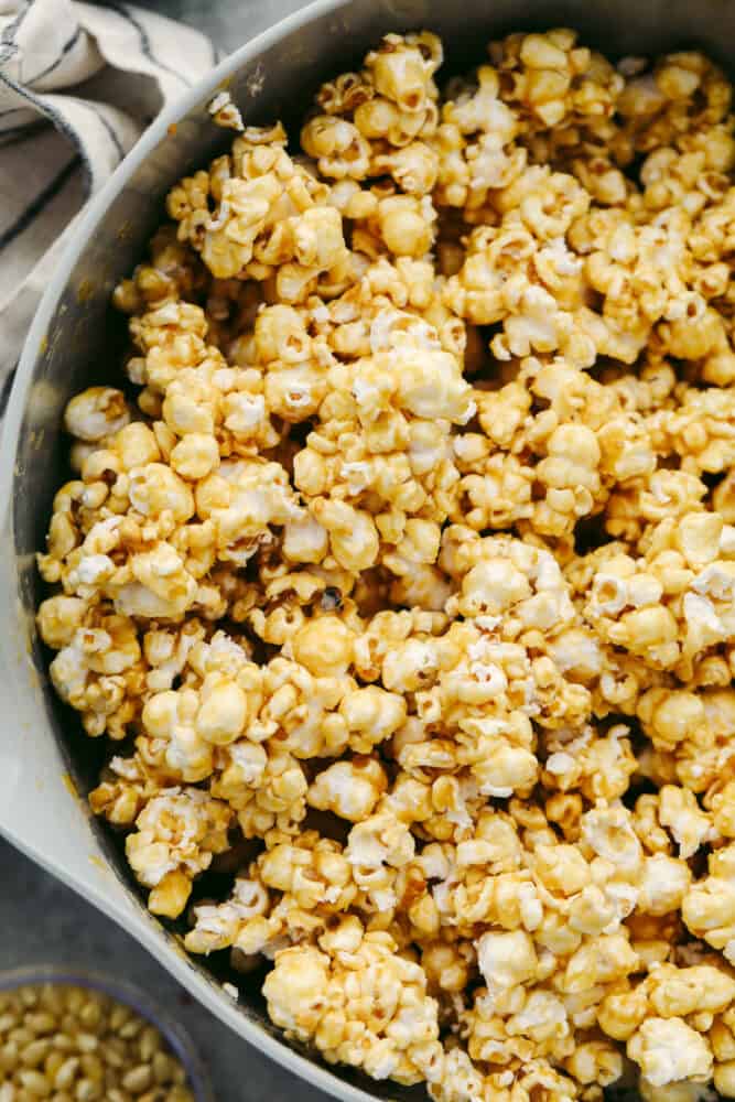 Homemade caramel popcorn is soft, sweet, and absolutely delicious! A family favorite, this homemade popcorn is something you will definitely want to add to your weekly movie nights! Caramel popcorn in a pan.