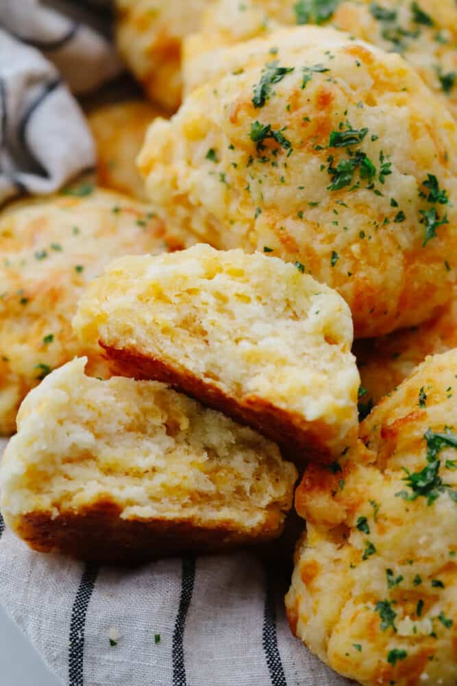 These delicious copycat Red Lobster cheddar biscuits are better than the real thing! Warm, buttery, and ready in 20 minutes! Closeup of a copycat Red Lobster cheddar biscuit broken in half.
