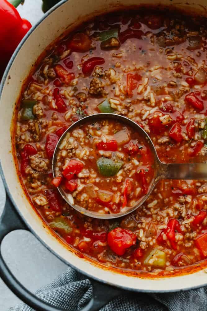 Stuffed pepper soup is delicious, hearty, and full of flavor! Filled with so many different ingredients, it's insanely good and will definitely fill your belly! A ladle in a pot of stuffed pepper soup.